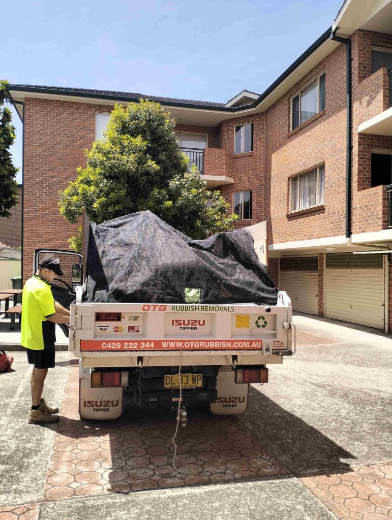 Otg Rubbish Removal Truck after fininshig garage clean up job with team member on the left side of the truck