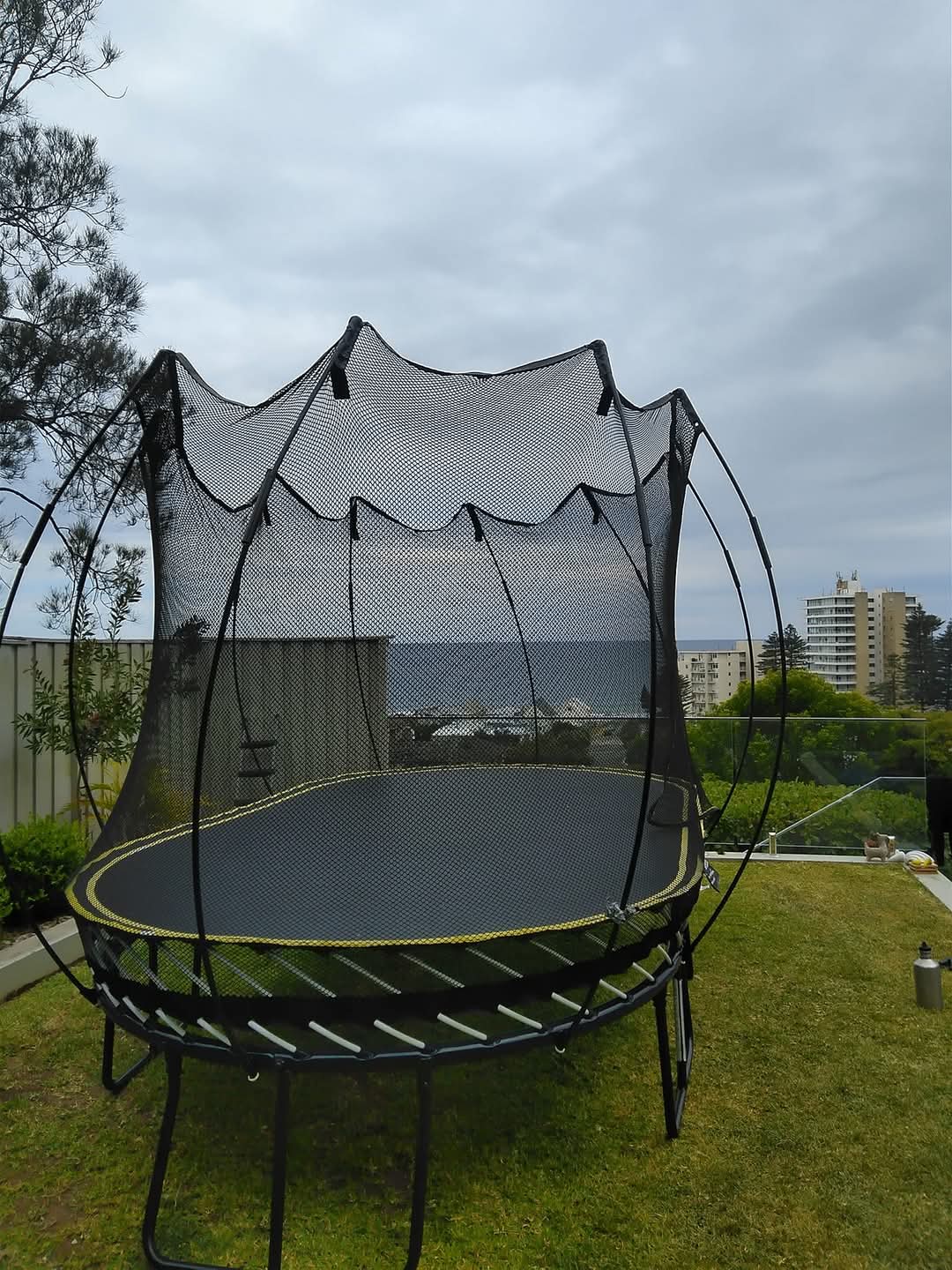 Springfree trampoline finally installed with final stages of the net and supporting rods installed